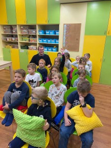 Děti sedí na židlích, které znázorňují letadlo a letí do Maďarska